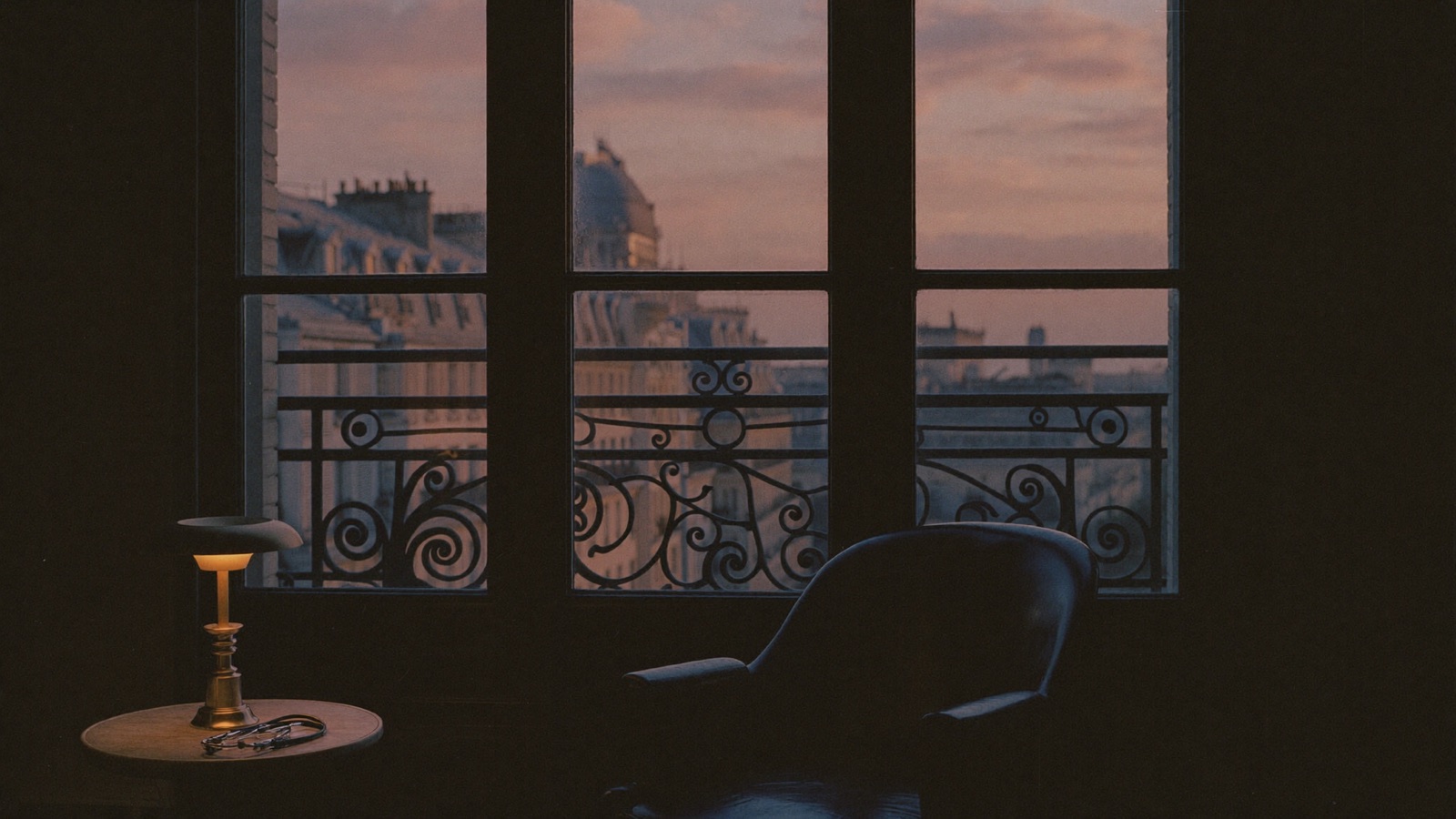 A private consultation salon at dusk overlooking the rooftops of Paris